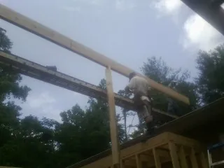 Carpenter setting a ridge beam over a new addition frame — Ice Dam Removal by Roofing Brothers in Uxbridge