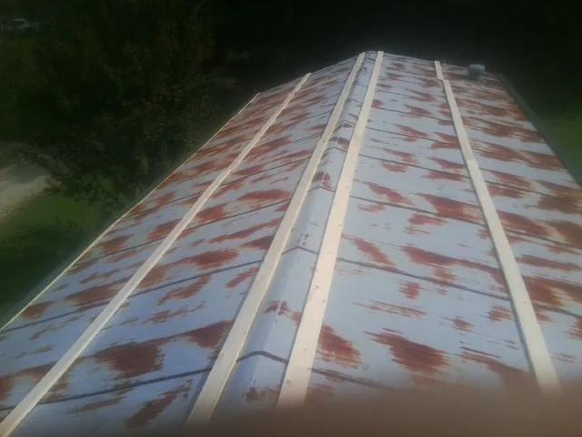 Rusted metal roof panels with new wood purlins before replacement — Storm Damage Roof Repair in Uxbridge by Roofing Brothers