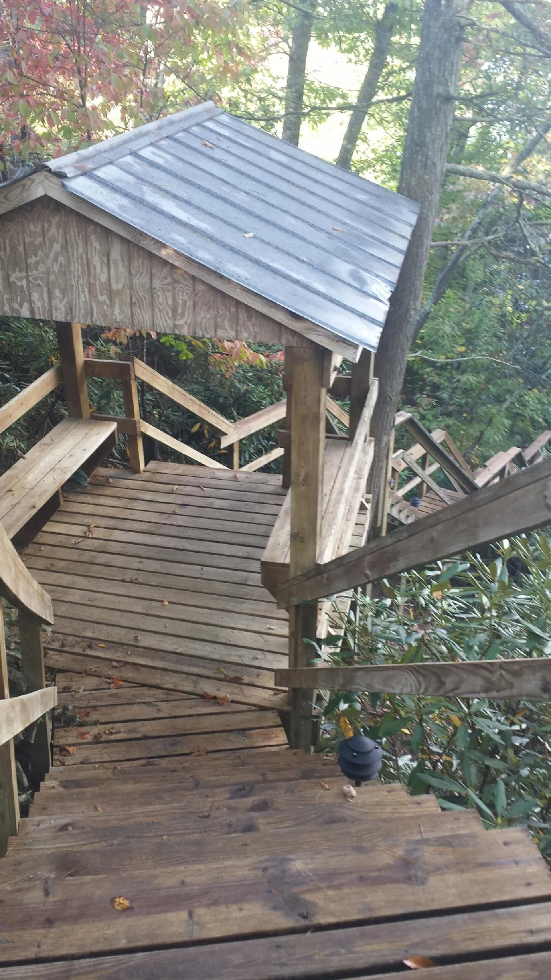 Metal roofed shelter over wooden steps on a wooded walkway — Skylight Repair & Installation work by our crew in Uxbridge