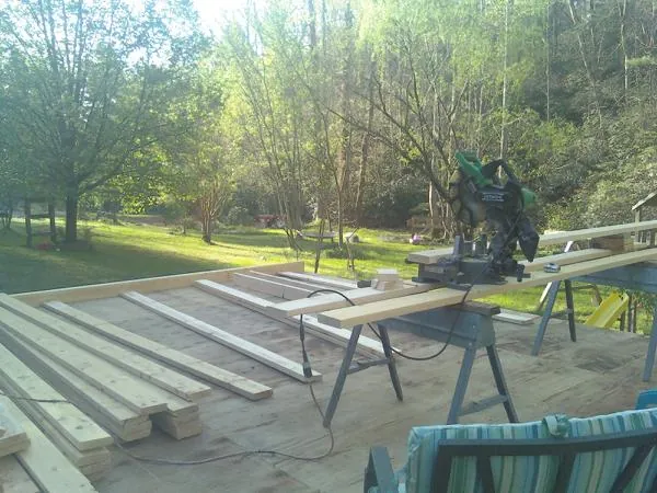 Miter saw and framing lumber on a deck under construction in Uxbridge