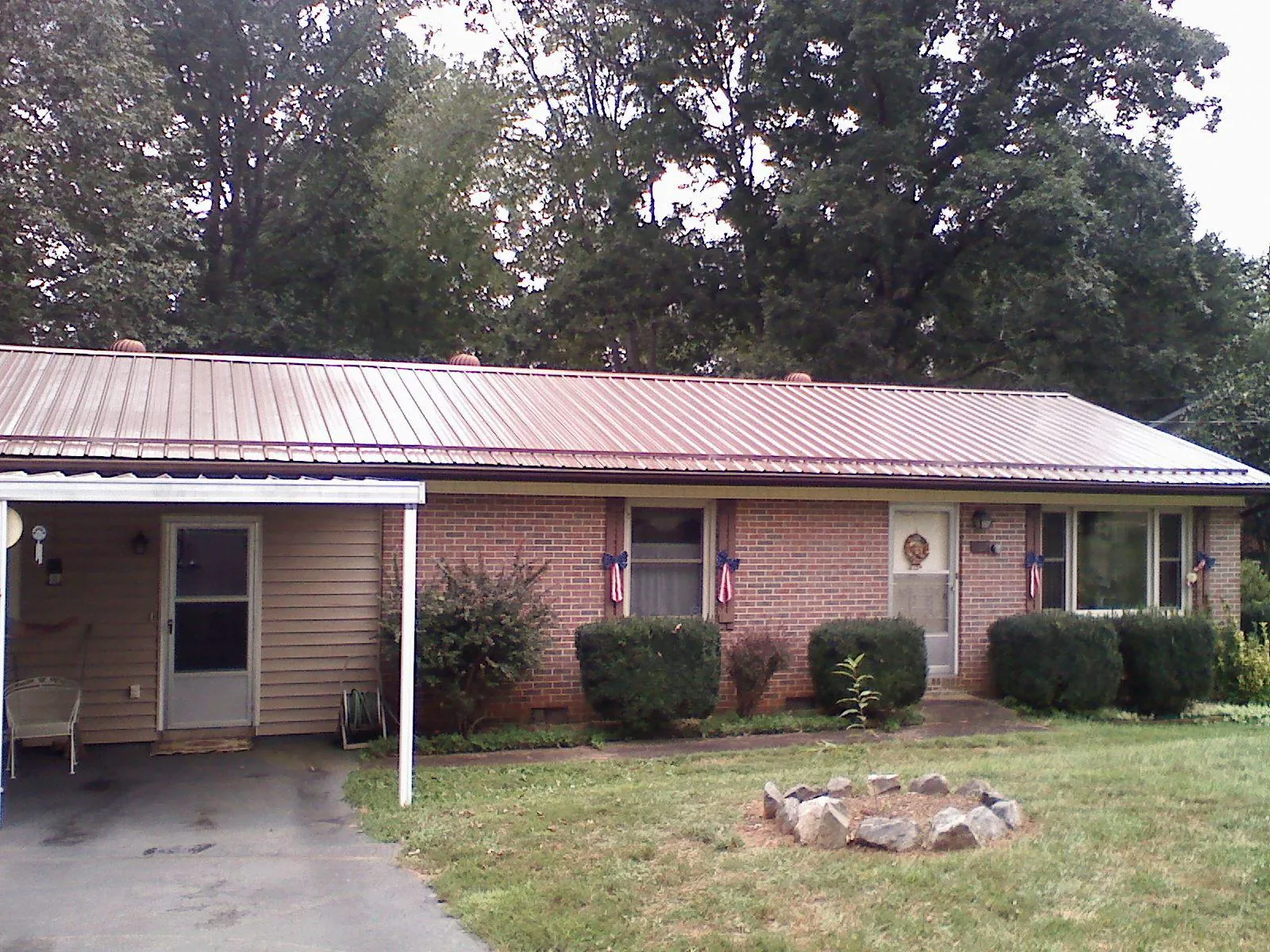 Bronze metal roof and carport on a brick ranch home — Roof Repair work by our crew in Uxbridge